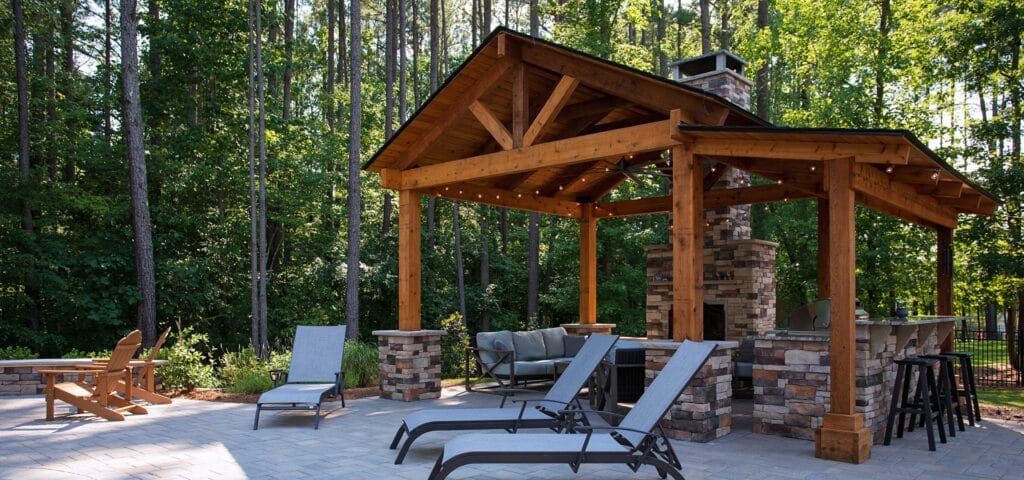 Panoramic view of pavilion with firepit and out door kitchen designed and built by Setting Sun Patio and Decks.