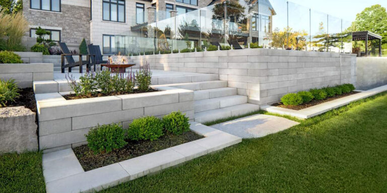 Outdoor patio featuring steps and retaining wall with shrubs.