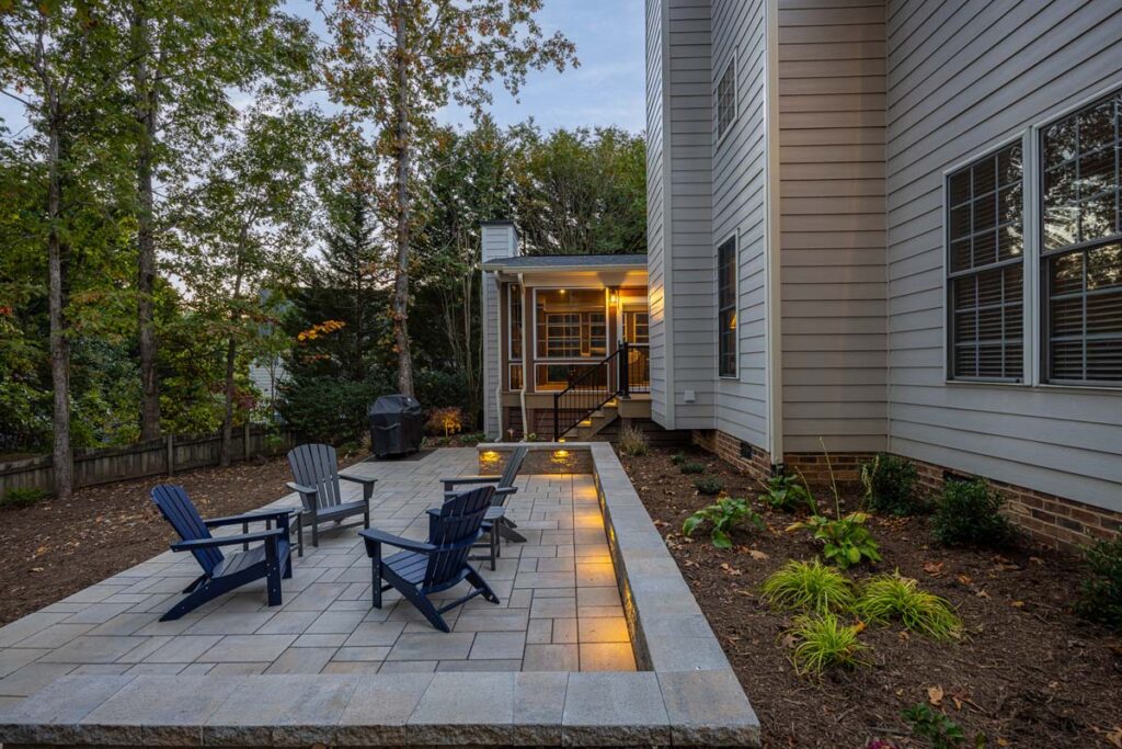 Wide shot view of Banyon Tree deck with patio on the right and retaining wall on the left.