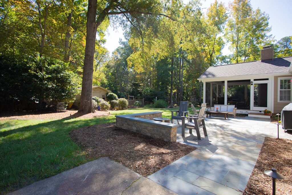 Outdoor view showing screen deck of the Coachmans Way project. Showcasing firepit and 3 patio chairs.