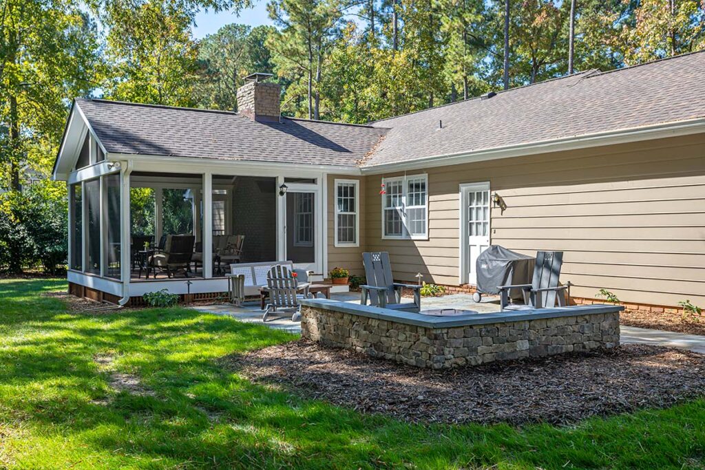 Outdoor view showing screen deck of the Coachmans Way project. Showcasing firepit and 3 patio chairs.