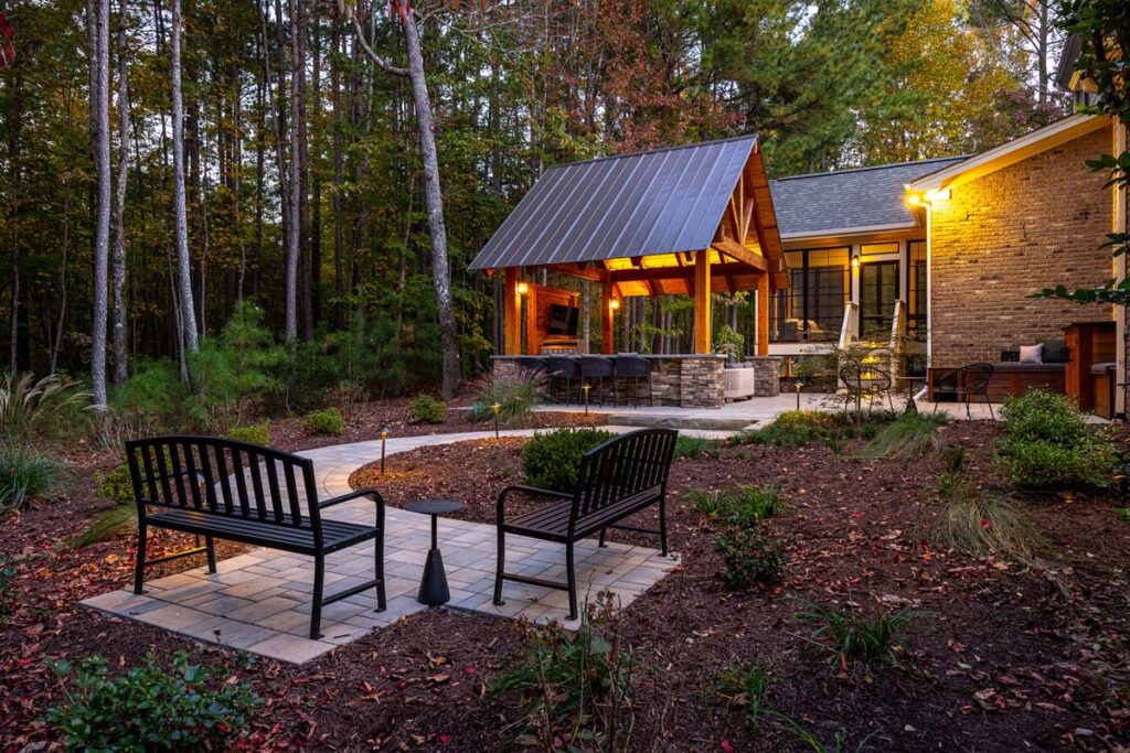 Wide shot of Colvard Park in the evening with two benches in the foreground and pavilion and deck in the background.