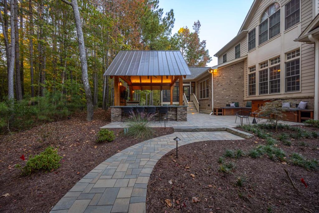 Techo-bloc pavers leading towards patio area with Colvard Park pavilion in the center and composite deck in the background.