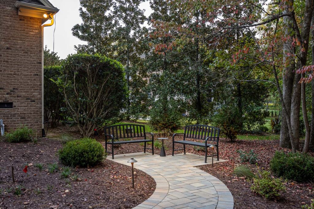 Close up of Colvard Park walkway leading to two benches.