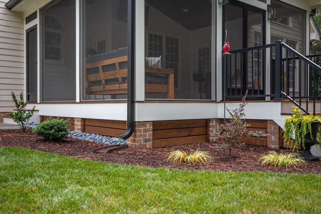 Three-quarter close up of Jasper deck, highlighting deck's foundation and screened deck's interior.