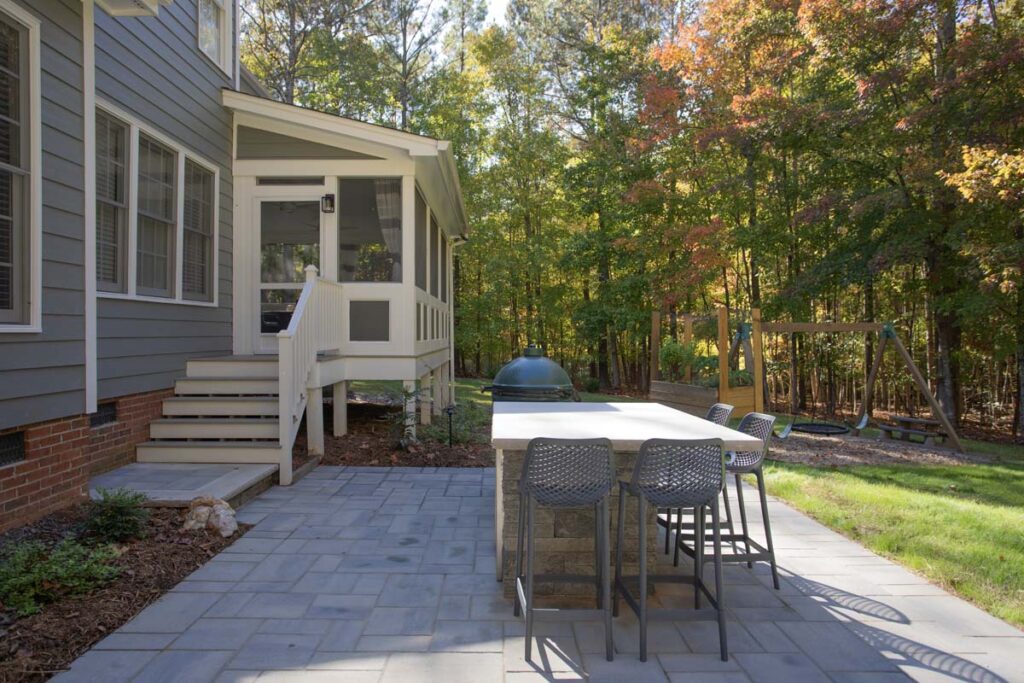 Patio area of North lake with Techo-Bloc pavers. Featuring outdoor grill with countertop, showing entrance to screen deck.