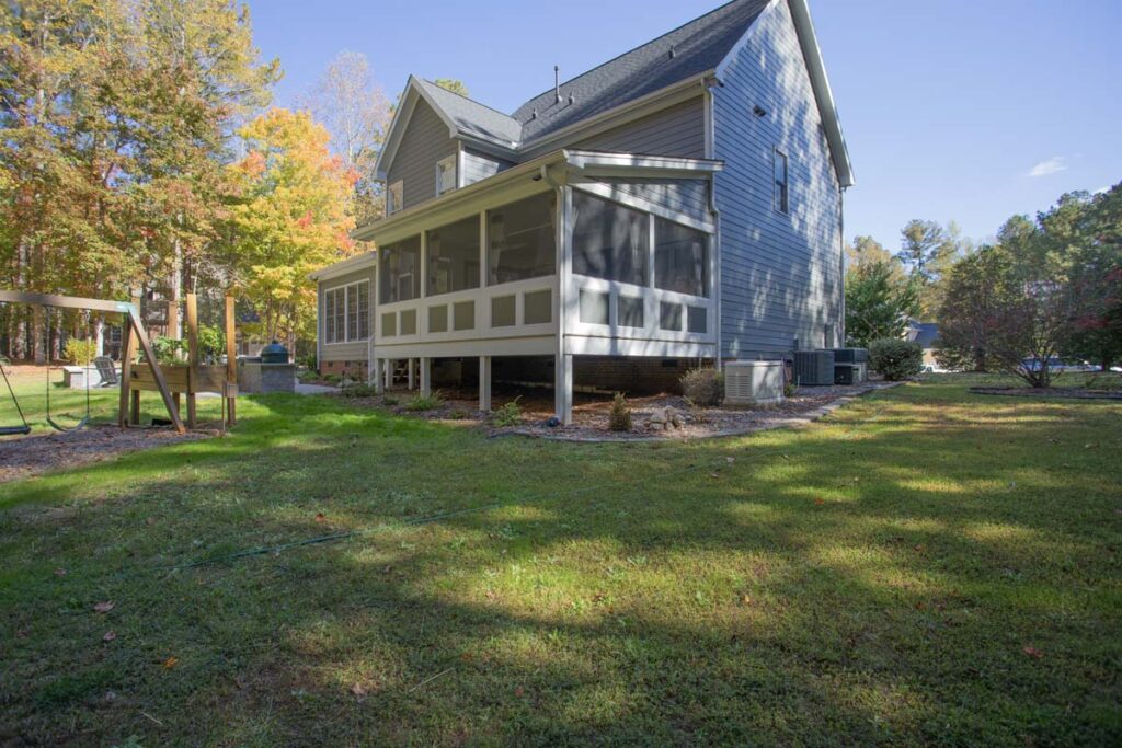 Corner view of Northlake project featuring screen deck and a swing set and patio area on the left.