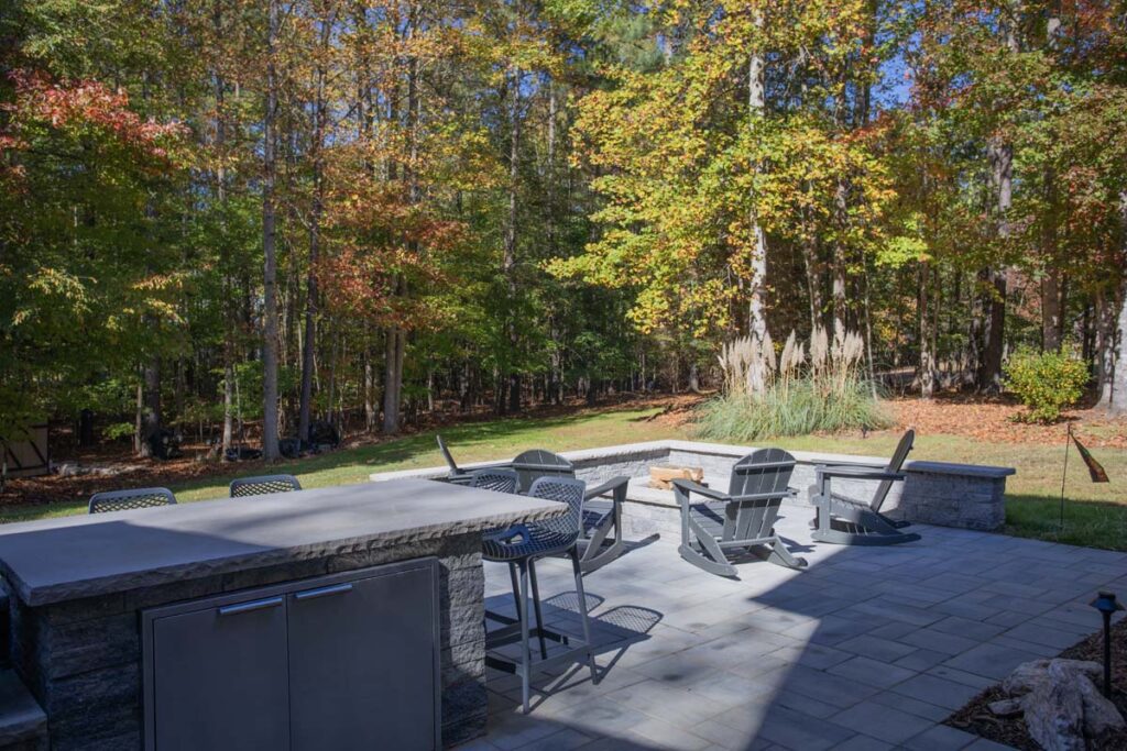 Wide shot of patio area of North lake with Techo-Bloc pavers. Featuring fire pit and countertop.