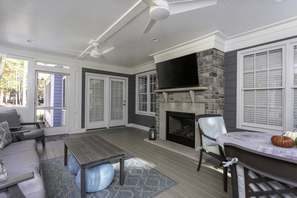 Interior deck of the Northlake project, showing fireplace with television, a dining table, sofa and coffee table.