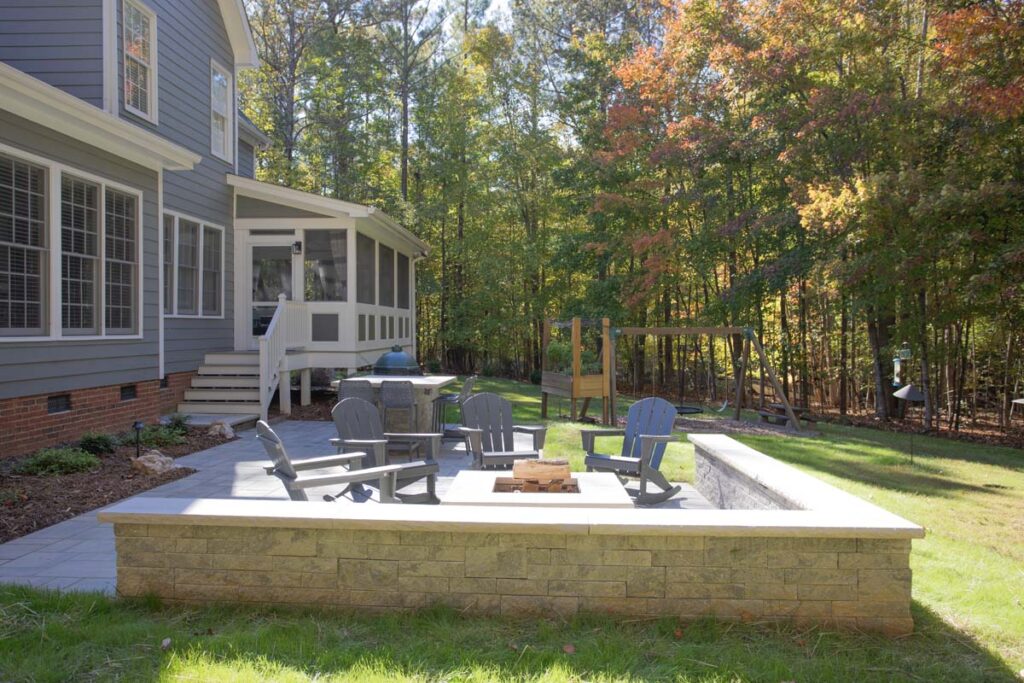 Patio area of North lake with Techo-Bloc pavers. Featuring fire pit and outdoor grill with countertop, showing entrance to screen deck.