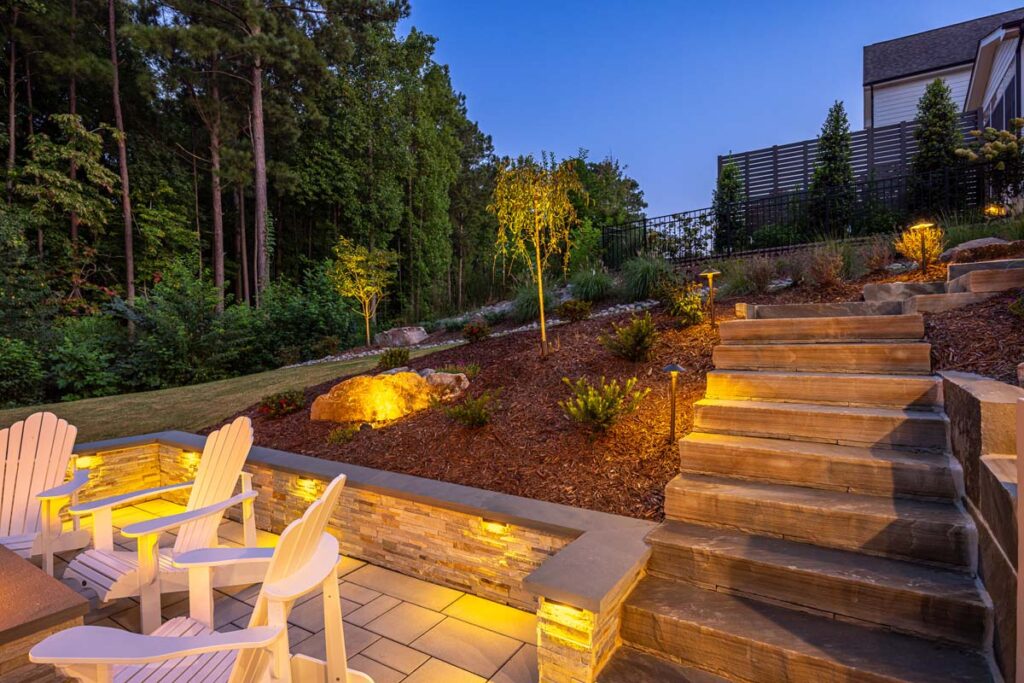 Close up of Roseroot steps leading towards deck, with evening scene highlighting low-voltage lighting.