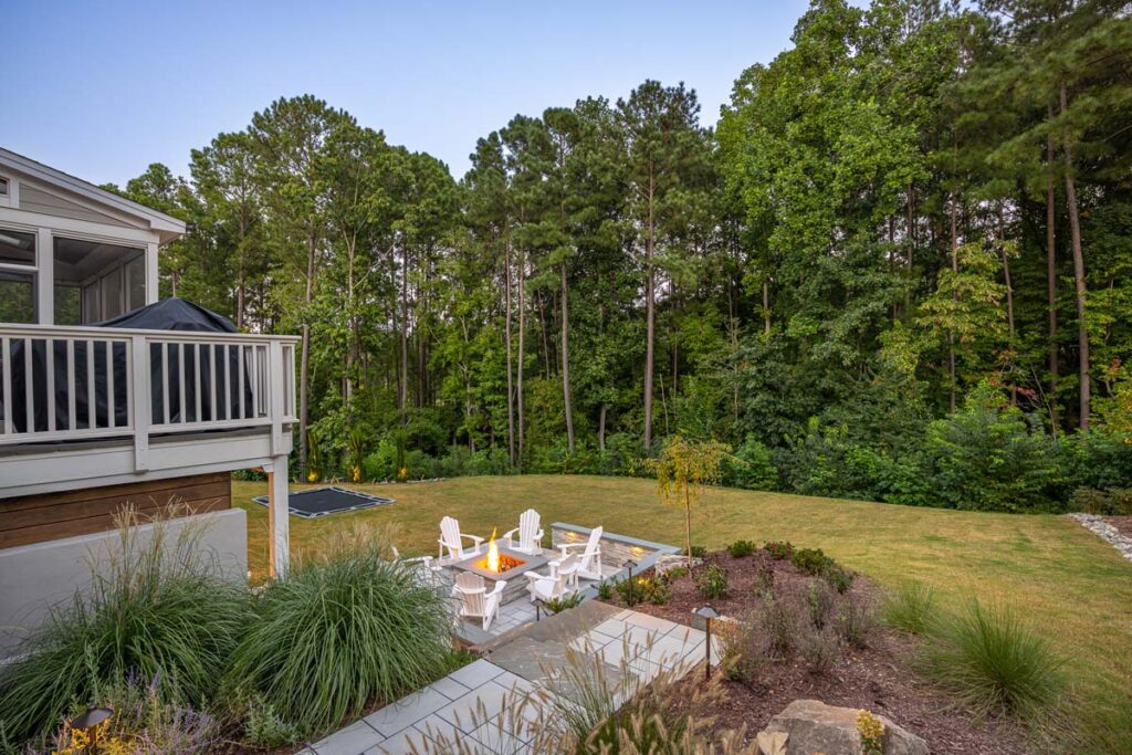 Drone shot facing towards forest showing walkway leading the patio in the foreground.