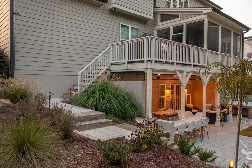 Angled view facing Roseroot deck with pathway leading to patio with fire place, featuring products from TimberTech and TechoBloc.