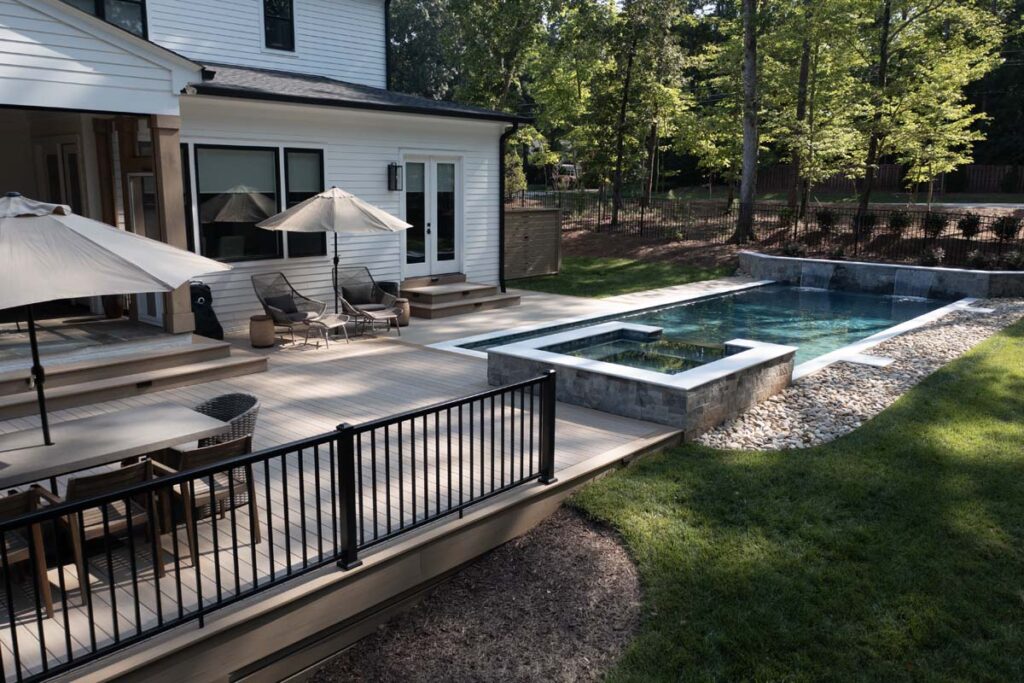 Wide shot view of Royal Amber patio showcasing TimberTech composite deck and custom pool.