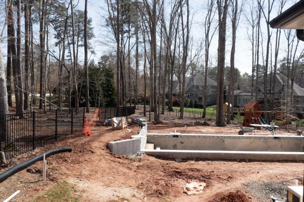 Side view of in progress Royal Amber pool with retain wall/waterfall on the left side.