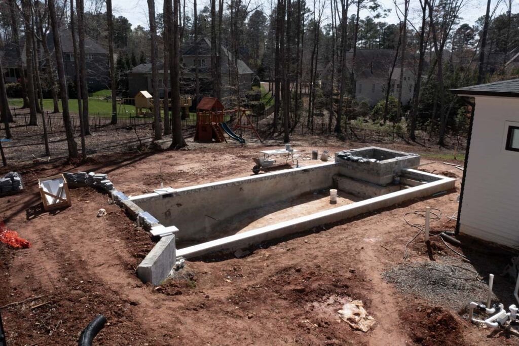 Top view of in progress Royal Amber pool with playground in the background.