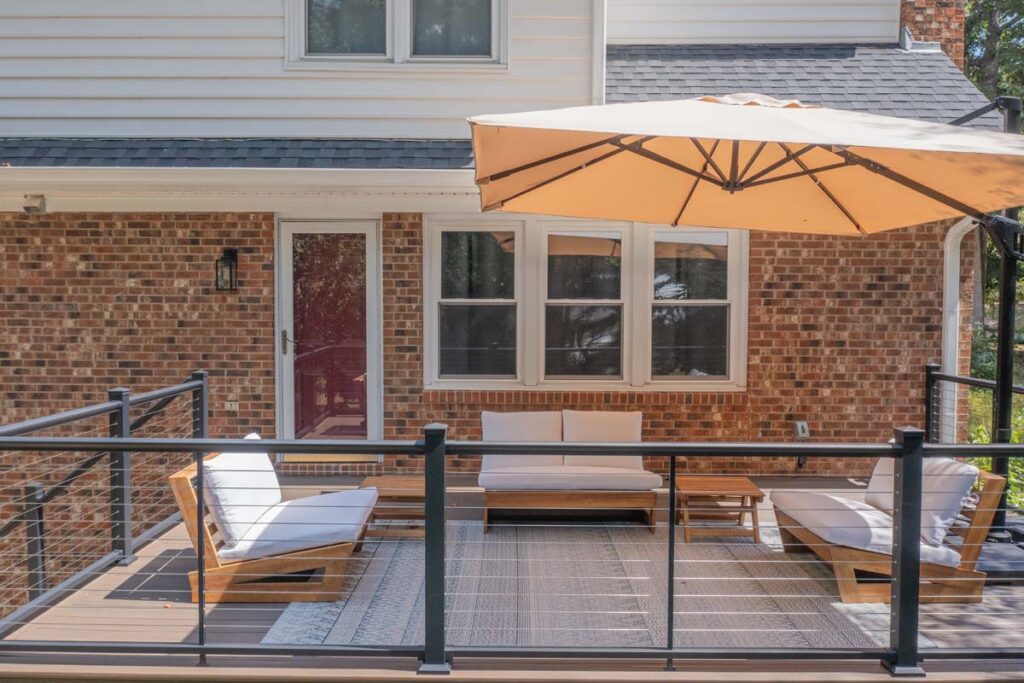 Front view of top deck of Rushing Brook, with three outdoor couches and patio umbrella.