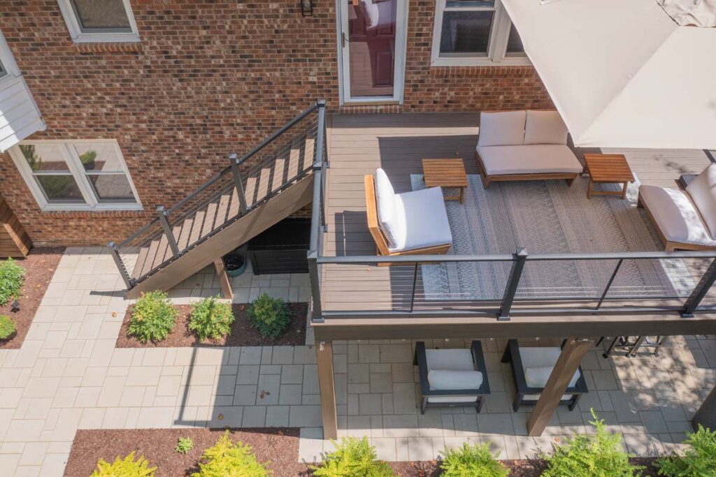 Drone view of Rushing Brook showing top of composite deck with gathering area on top and on bottom. With paver walkway on the left and deck on the right.