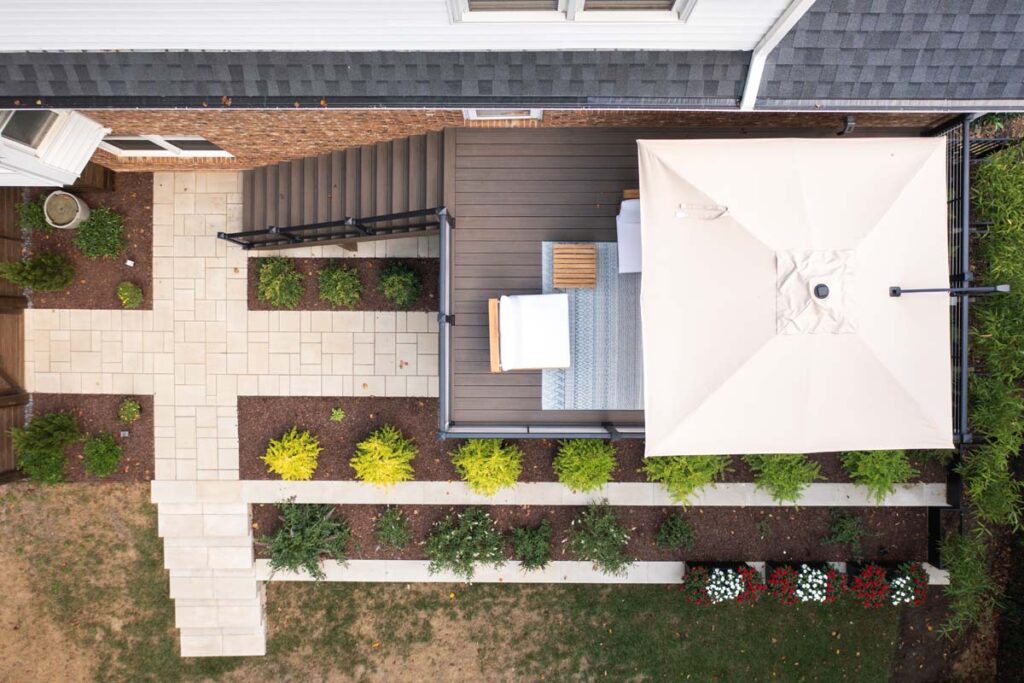 Top aerial view of Rushing Brook deck with entry door on the left and decking right. Revealing steps to backyard and two tier retaining wall.