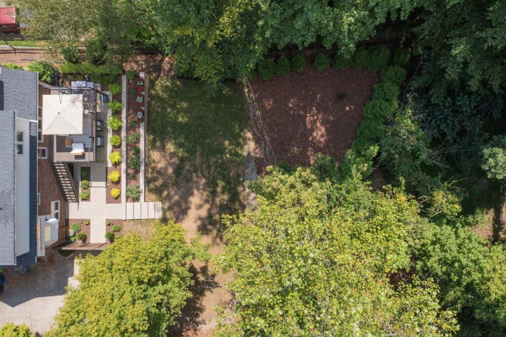 Top view of Rushing Brook patio, with composite deck, wooden entry door, steps and retaining wall.