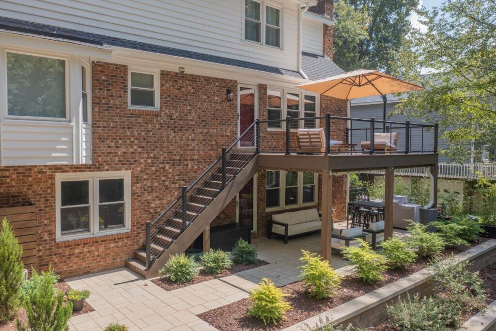 Wide shot of Rushing Brook patio, with composite deck, wooden entry door, steps and retaining wall.