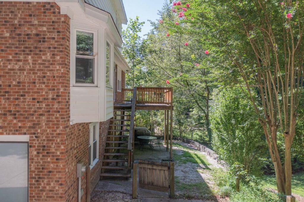 Top view of Rushing Brook before renovation, with wooden deck and overgrown lawn.