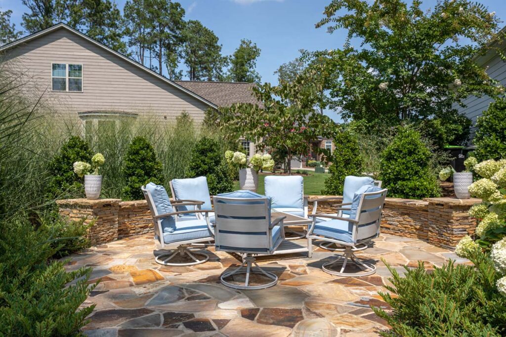 Front facing view of Silver Dew from walkway entrance, highlighting retaining wall and garden surrounding circular patio.