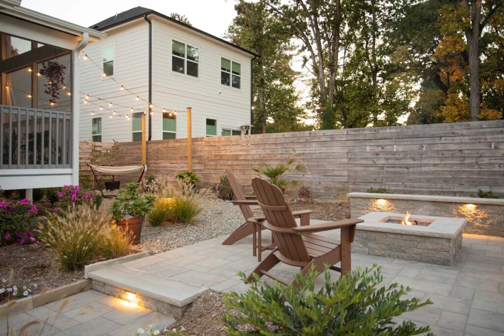 Wide shot of Steven patio project featuring, Techo-bloc pavers and fire pit. Revealing more of the deck area and hammock.