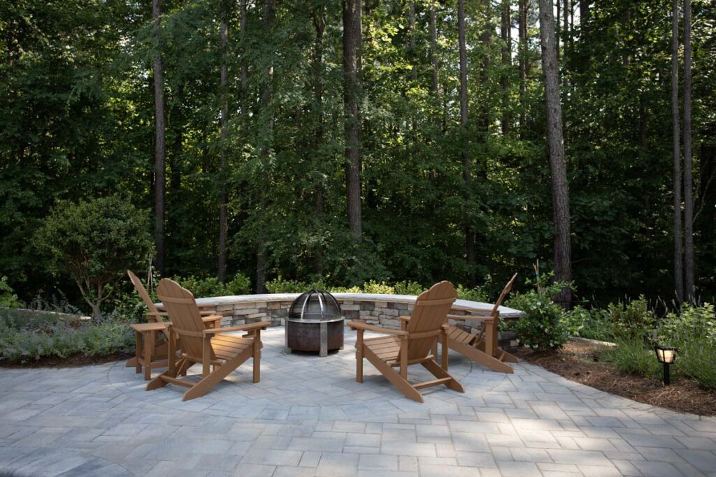 Swann Trail fire pit with four patio chair over looking the forest trees of the property.