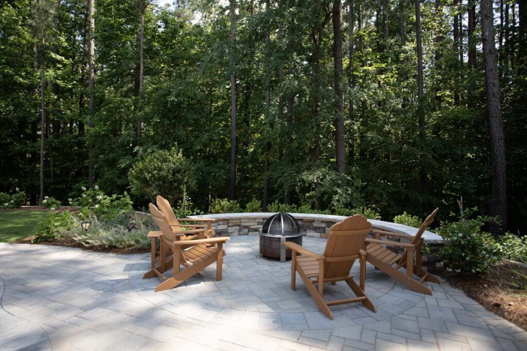 Swann Trail fire pit with four patio chair over looking the forest trees of the property.