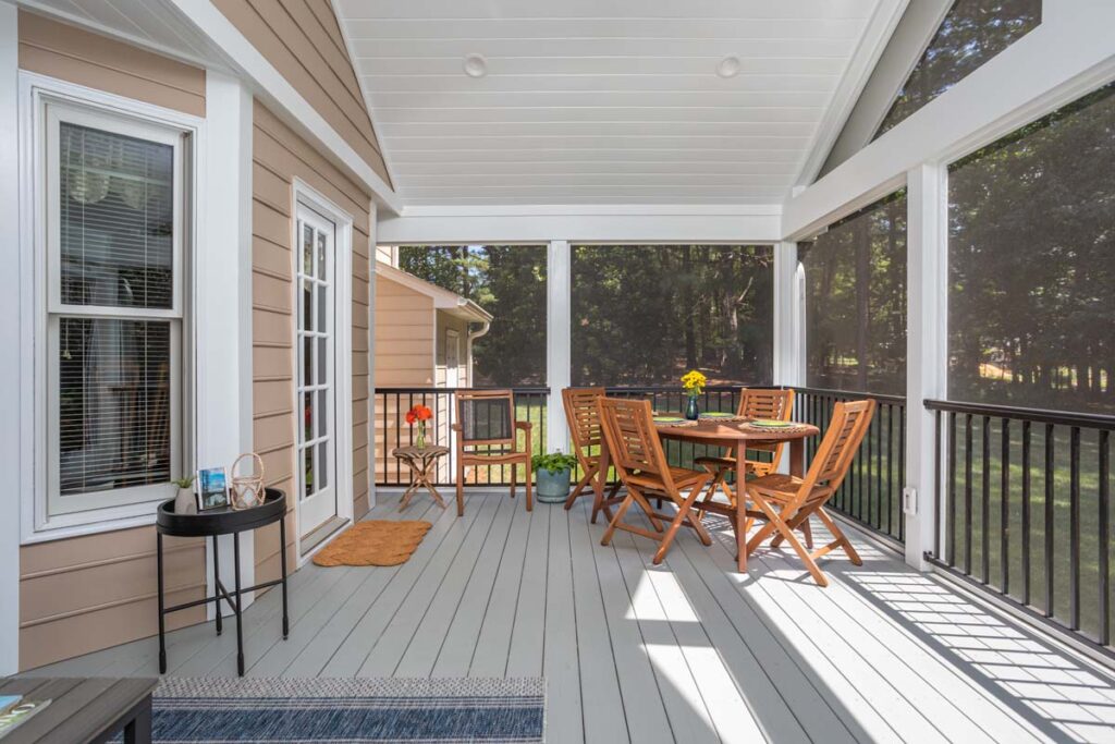 Direct right-facing view of Lowery interior deck, showing a patio table and chairs.