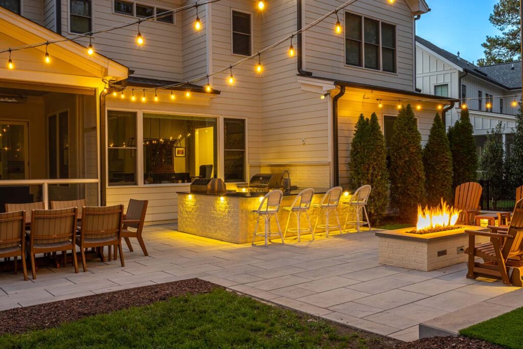 Corner view Skybrook Oak patio showcasing outdoor kitchen and fire pit on the right.