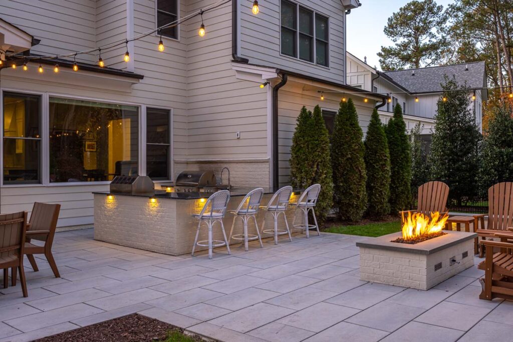 Corner view Skybrook Oak patio showcasing outdoor kitchen and fire pit on the right.