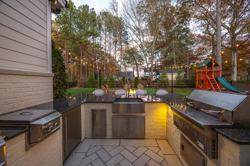 Close up shot focusing on Skybrook Oak outdoor kitchen, showcasing outdoor sink, grill, stove and outdoor appliances.