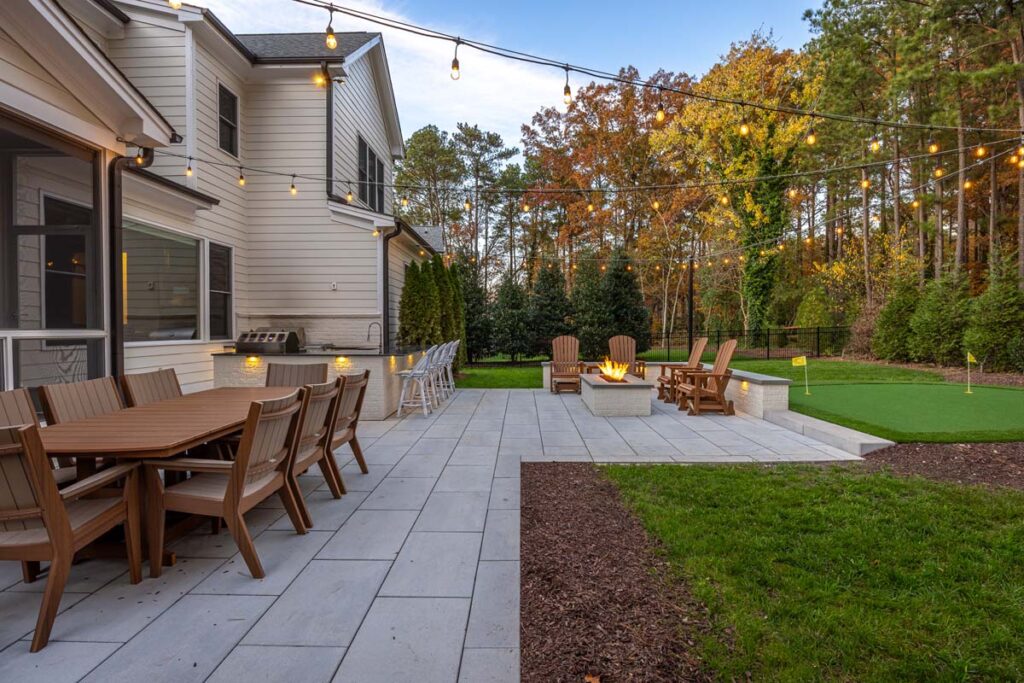 Side view of Skybrook Oak patio with Techo-Bloc pavers, fire pit and golf area.