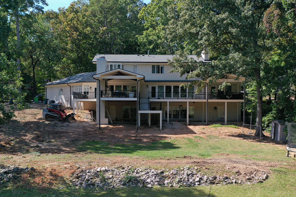 A wide-angle shot Sussex backyard showing a skid loader on the left side, with a graded backyard.